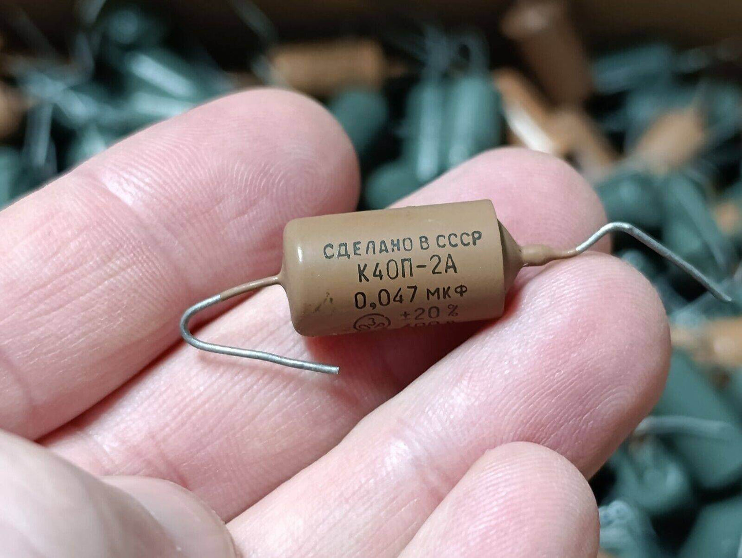 Hand holding a K40P-2A capacitor, made in the USSR, labeled 0.047 µF, showcasing its vintage design.