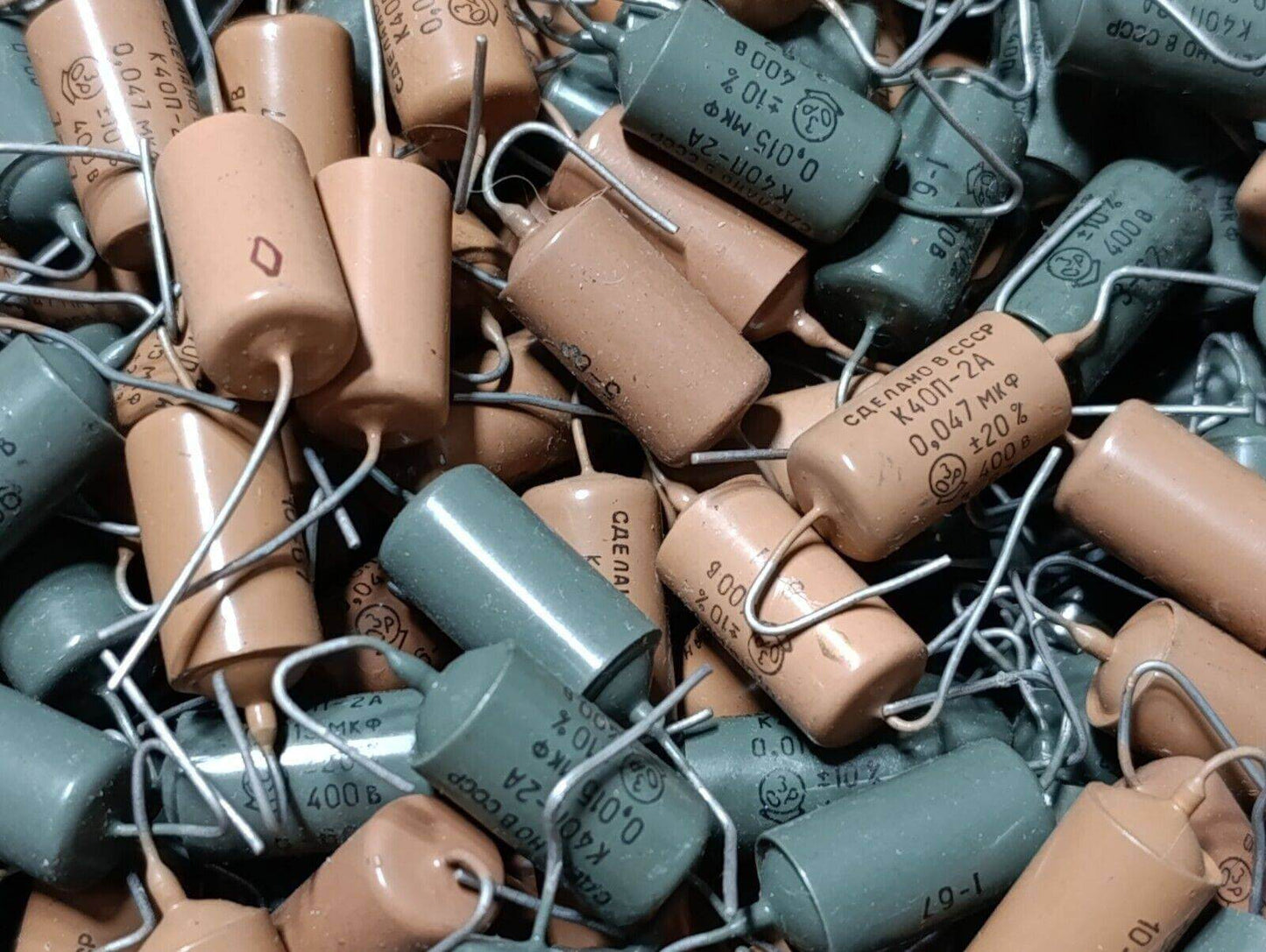 Vintage K40P-2A audio capacitors in various colors, ideal for guitar tone enhancement, showcasing old stock from Odesa Radio Factory.